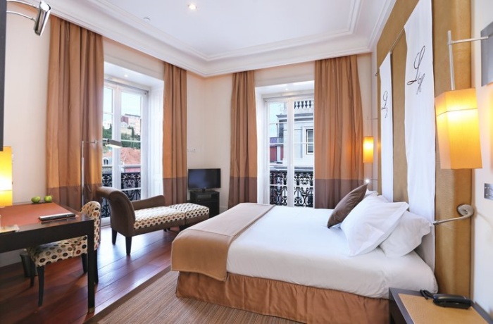 Eines der Zimmer des Hotels, elegante Einrichtung in der Mitte des Bildes ist das Bett.