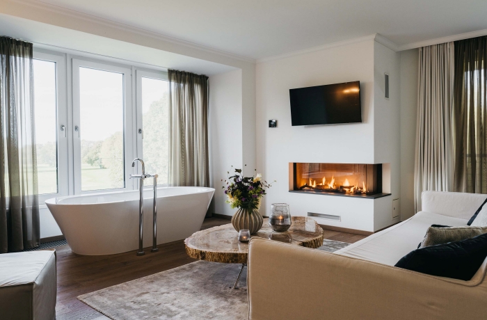 Luxuriöse Wellness-Suite mit freistehender Badewanne und Kamin im Landhotel Voshövel am Niederrhein.