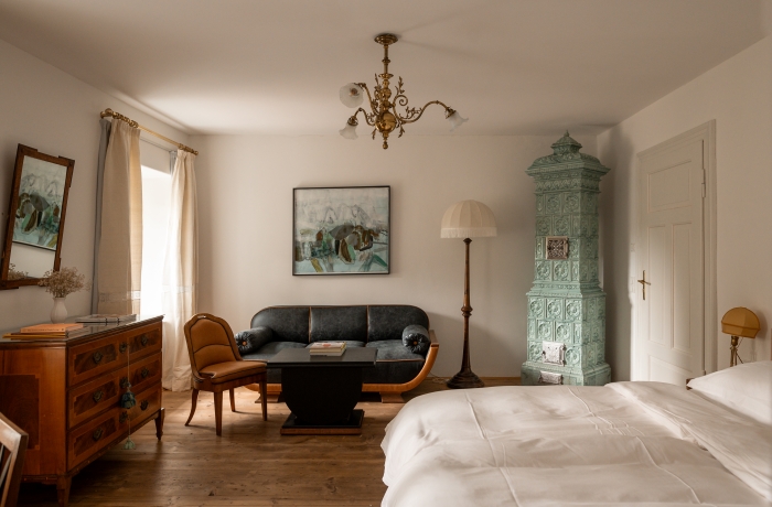 Elegantes Zimmer mit historischem Kachelofen und Vintage-Design im Ottmanngut Suite & Breakfast in Meran.