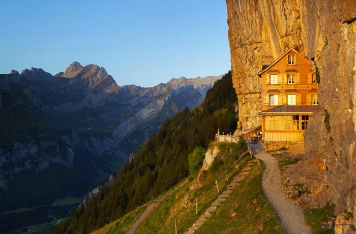 kleines Berghotel am Abhang mit Panoramablick auf Berge