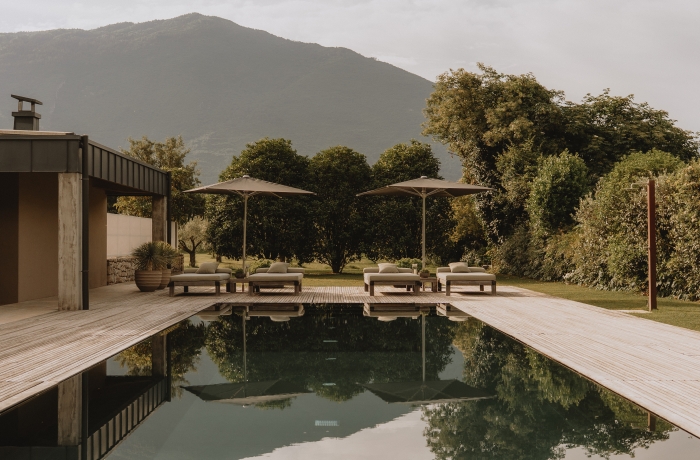 Außenpool der Vivere Suites & Rooms mit Sonnenterrasse und Blick auf die mediterrane Berglandschaft.