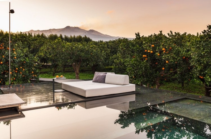 Ein Designjuwel auf Sizilien und auch 2025 michelin-prämiert: Hier schaut man vom Designpool auf einen Orangengarten
