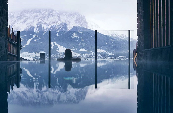 Wellnesshotels: Pure Lermoos - Tirol, Österreich mit Rückenansicht von einer Frau im Pool und Blick auf Berge