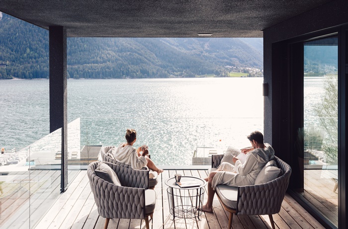 Zwei Menschen auf einer Terrasse mit Blick auf den See