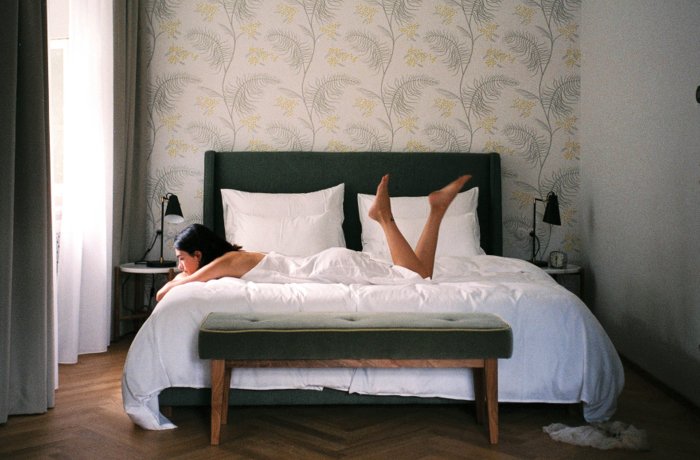 Hotels für Erwachsene: Frau liegt verträumt auf Bett in der Villa Arnica, Trentino Südtirol, Italien