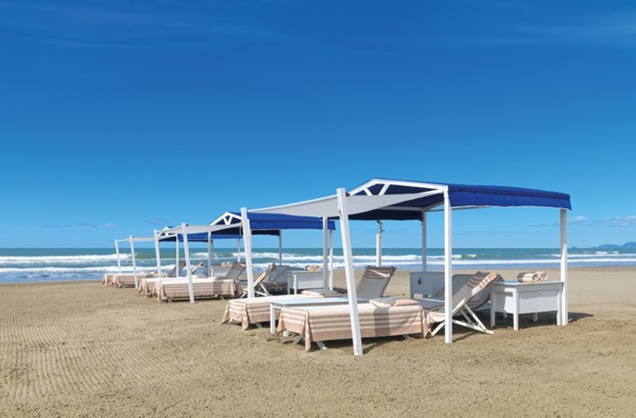 Breiter Sandstrand mit privaten Kabinen für Sonnenliegen und Safe