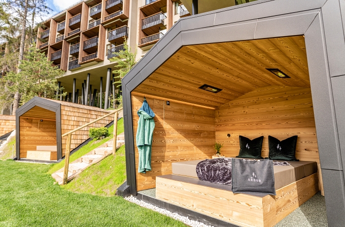 Hüttenartige Ruhebetten im Außenbereich des Wellnesshotels My Arbor