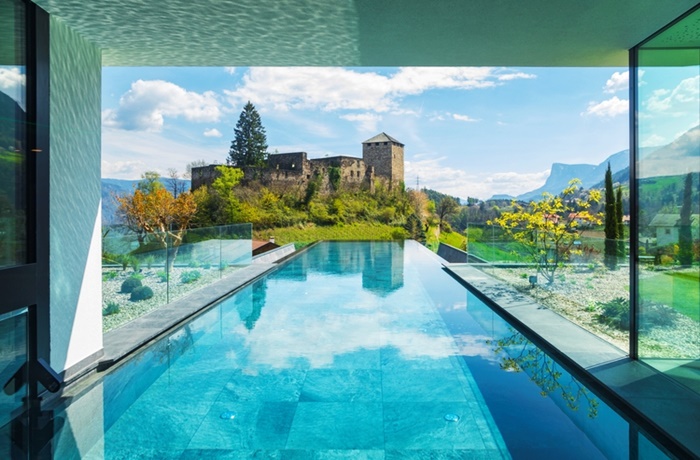 langer Outdoor Infinitypool mit Blick auf eine Burg