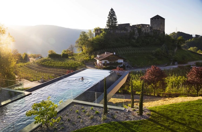 langer Infinitypool mit Blick auf Berge und Burg