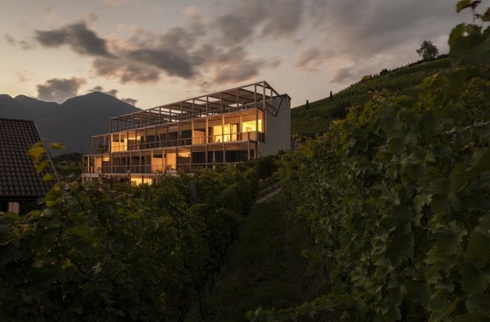 Aus den schon nachtdunklen Weinreben steigt das Gebäude des Haller Suites & Restaurant hervor, gemütlich beleuchtet und terrasenförmig - so hat man von überall aus eine schöne Aussicht aus Sonnenuntergänge