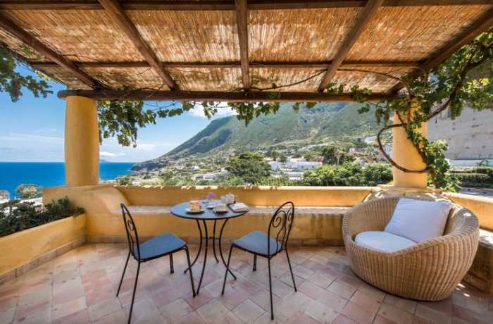 Badeurlaub: Ein charmantes Hotel mit mediterranem Flair und Blick auf das glitzernde Meer lädt zu einem erholsamen Aufenthalt ein.