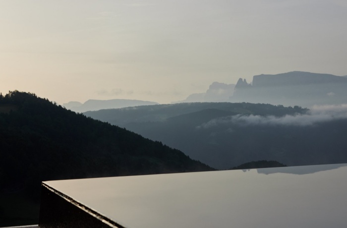 Spektakuläre pools: Hoch liegender Infinitypool in dem sich der Himmel spiegelt, Panoramablick auf Himmel und Berge
