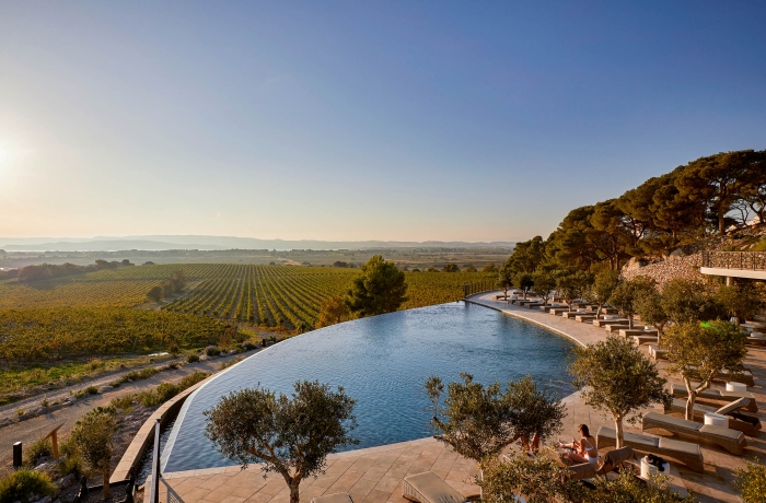 Infinitypool des Château Capitoul mit Blick über Weinberge in Südfrankreich.