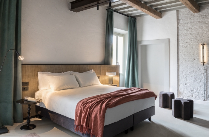 Stilvolles Hotelzimmer mit historischen Holzbalken, modernem Design und heller, eleganter Einrichtung für entspannten Wohnkomfort.