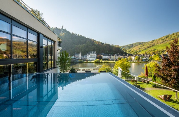 Außenansicht von einem Wellnesshotel in grüner Natur mit Außenpool im Moselschlösschen Spa & Resort | Adults only