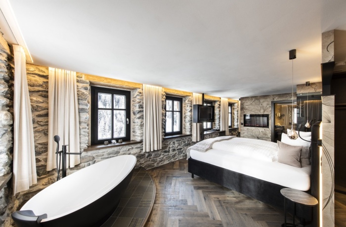 Romantische Hotelzimmer für Paare: Steinoptik, eine freistehende Badewanne und ein Kamin sorgen hier für Wohlbefinden.