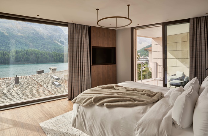 Schlafzimmer mit Balkon und Panoramafenster mit Blick auf den See 