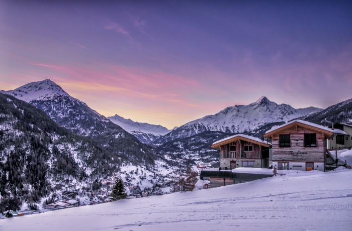 Chalets und Apartments von außen inmitten der bergigen Schneelandschaft