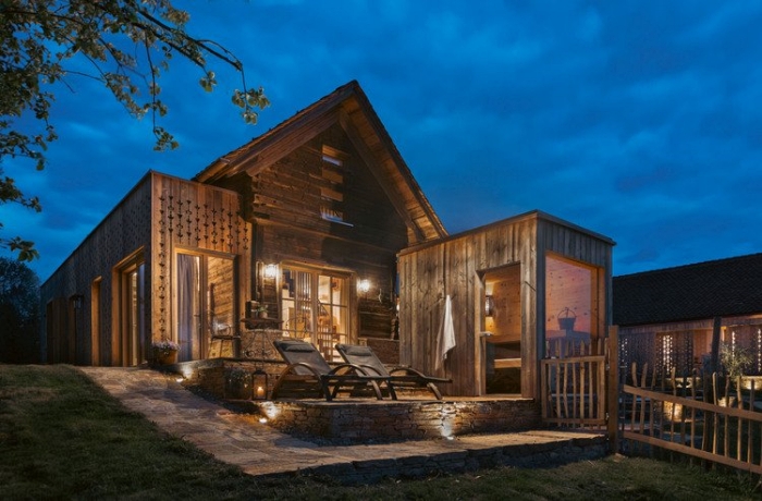 Bei den hölzernen Chalets befindet sich die Privatsauna draußen, neben der steinernen Terrasse mit Liegestühlen