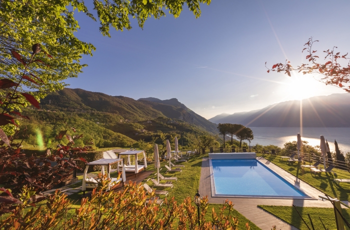 Großer Pool mit liegen und Blick auf den See und Berge