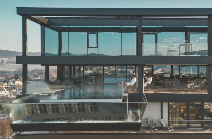 Modernes Spa-Hotel mit Infinity-Pool und weitem Blick über eine Landschaft, ideal zum Entspannen.
