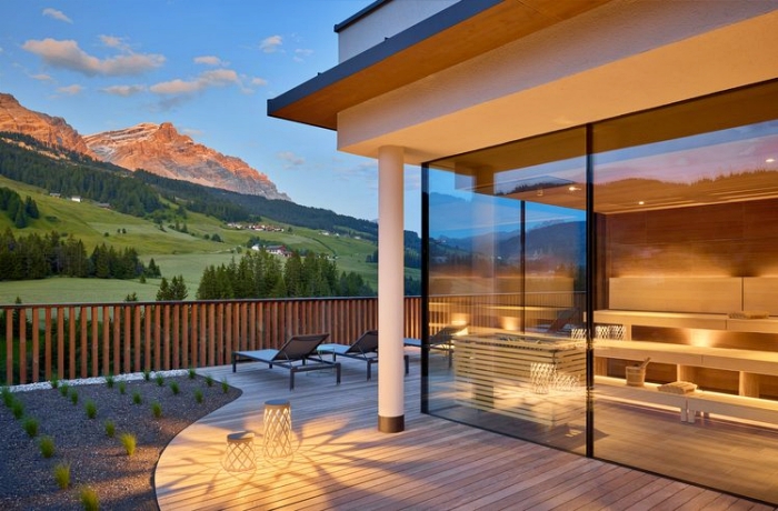 Einer unserer Top Sunset Spots – der teilweise auf dem Dach gelegene Wellnessbereich dieses Südtiroler Hotels mit Blick auf die Berge und Weiden.