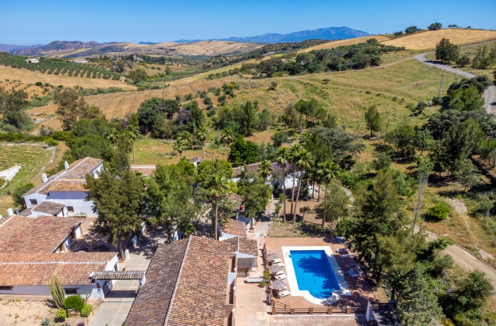 Finca mit Pool in der Sierra de las Nieves bei Málaga, umgeben von Hügeln und Olivenhainen.