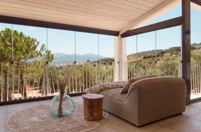 Panorama-Lounge der Hacienda Fresneda María mit großen Fenstern und Blick auf die Berglandschaft.