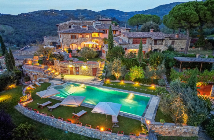 Das Borgo Savignola liegt eingebettet in die sanften Hügel der Toskana und begeistert mit historischer Natursteinarchitektur, mediterranen Gärten und einem beleuchteten Außenpool. Die stimmungsvolle Abendbeleuchtung unterstreicht den authentischen Charme des Landguts und die ruhige Atmosphäre inmitten der Weinlandschaft.