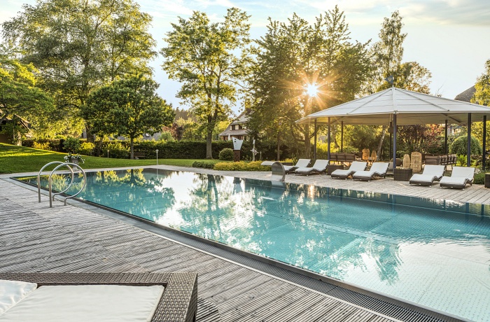 Das Parkhotel Adler, eines der Hotels mit Pool draußen in einem grünen Gartenbereich mit Liegen.