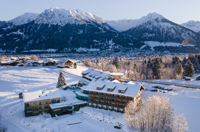 Im verschneiten Tal ist die Hotelanlage des Hotel Oberstdorf zu sehen.