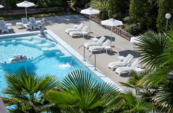 Großzügiger Außenpool im Albano Grand Hotel mit Sonnenterrasse, Palmen und stilvoller Gartenanlage – ideale Bedingungen für entspannte Urlaubstage.