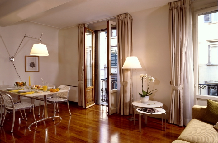 Helles Apartment mit Essbereich, Holzboden und französischem Balkon.