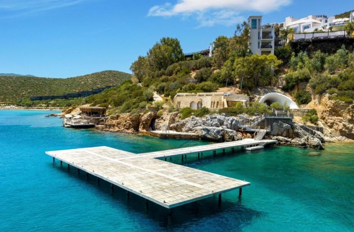 Steg der von einem Hotel mit Privatstrand aufs Wasser führt