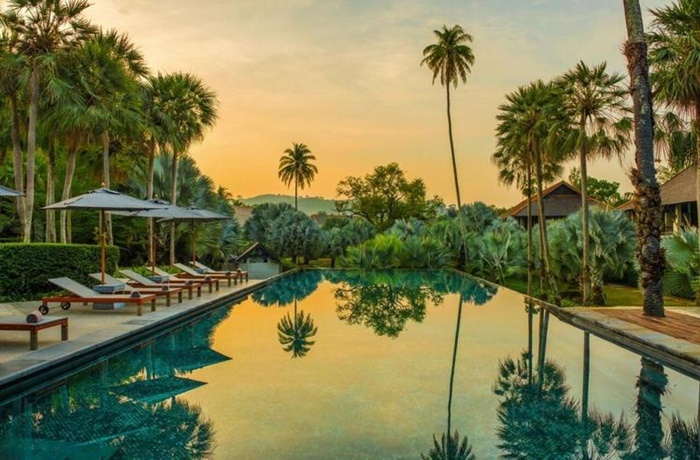 Pool mit Liegen und Sonnenuntergang mit Blick auf den Dschungel 