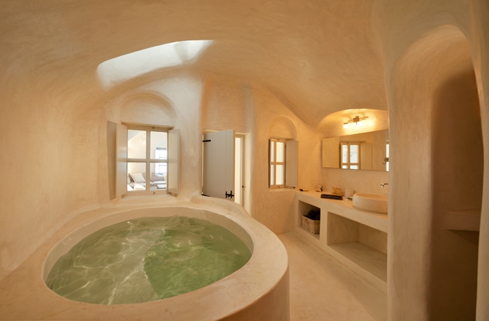 Ein fantastisches Designhotel in Griechenland – ein helles Badezimmer mit großer Wanne erwatet Gäste hier in einigen Zimmern