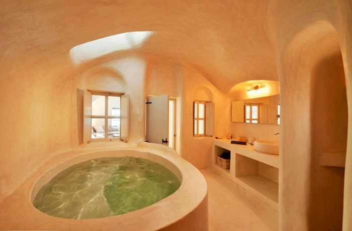 Badezimmer in höhlendesign mit rundgeschliffenen Wänden und großer Badewanne