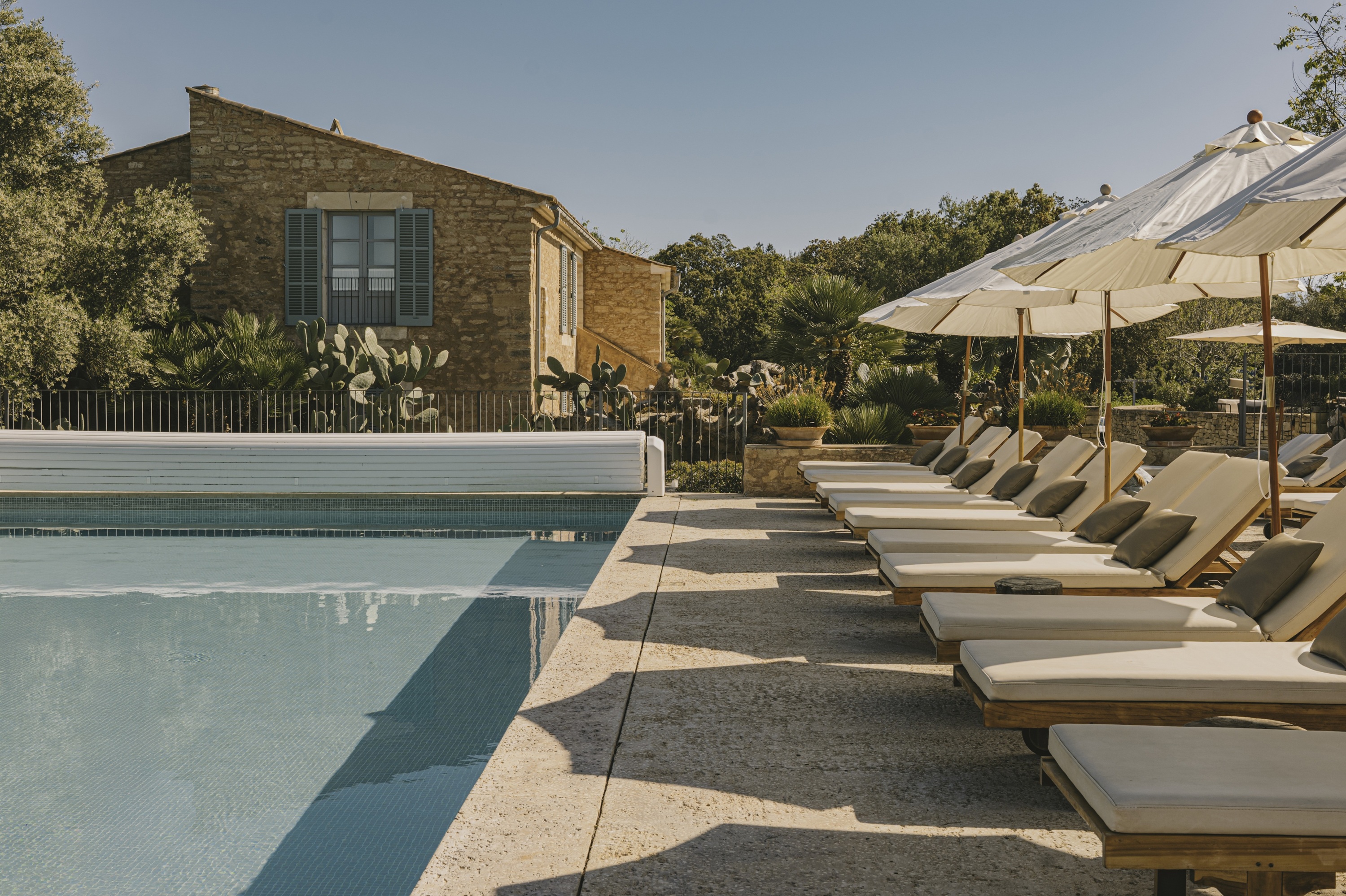 Mediterraner Hotelpool mit Sonnenliegen und Natursteinhaus im Hotel Predi Son Jaumell auf Mallorca.