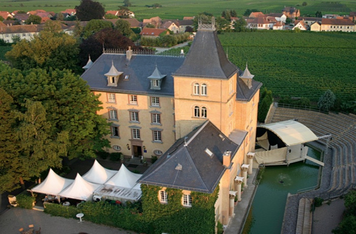 Blick auf das Schlosshotel von oben, im Hintergrund wachsen Weinreben