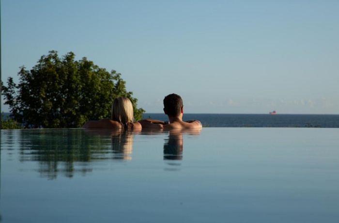 Paar lehnt mit Blick aufs Meer im Infinitypool des Ahlbeck Hotels & SPA auf Usedom.