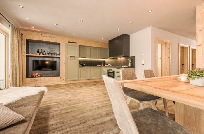 Apartment aus Holz mit grüner Designer Küche und Kamin