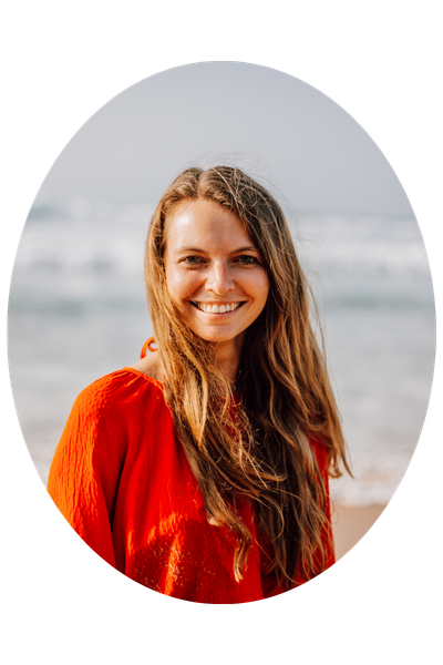 Top 50 Reiseblogs: Christine Neder posiert in roter Bluse am Strand