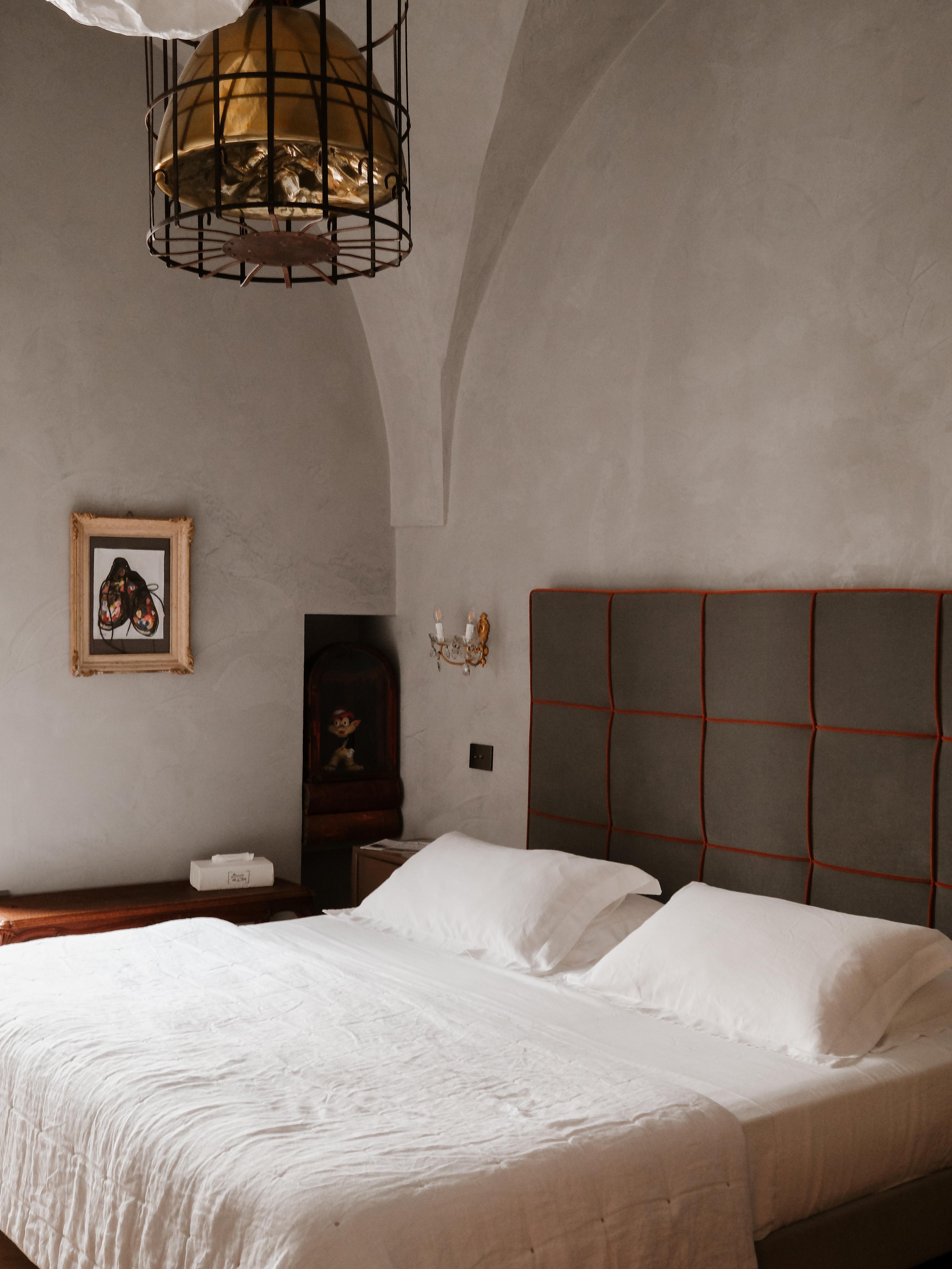 Blick auf ein an einer Wand stehendes Boxspring-Hotelbett