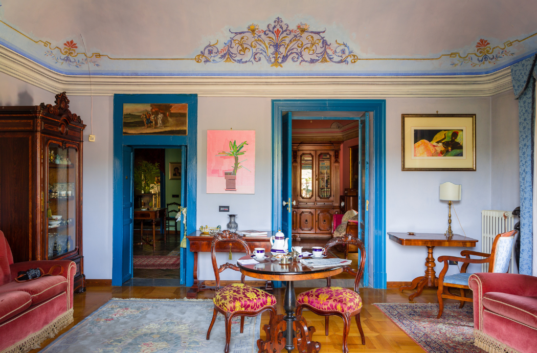Historischer Salon mit antiken Möbeln, Teetisch und kunstvoll verzierter Decke.