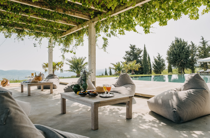 Entspannte Lounge-Terrasse mit Pergola und Pool in mediterraner Umgebung.