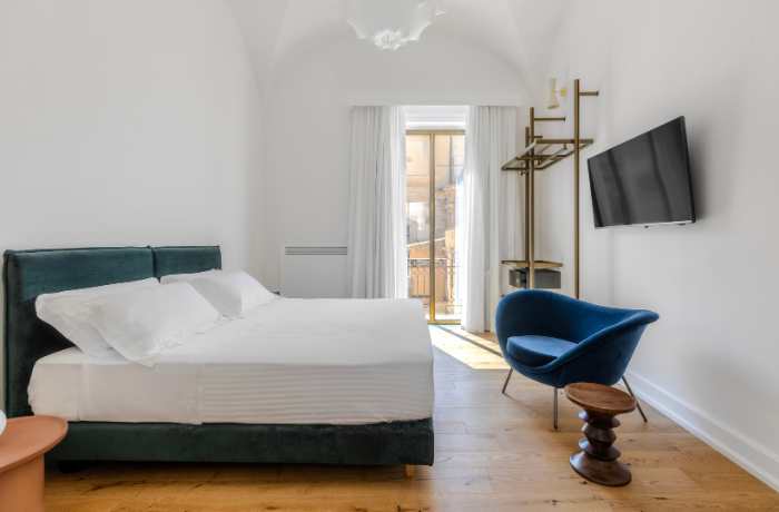 Elegantes Zimmer im Dome Hotel mit modernem Design, Gewölbedecke und französischem Balkon.