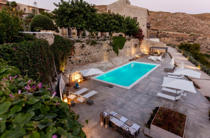 Historisches Boutique Hotel mit Außenpool und Natursteinarchitektur in mediterraner Landschaft.