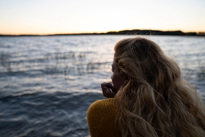 Eine Frau blickt auf einen See in Finnland