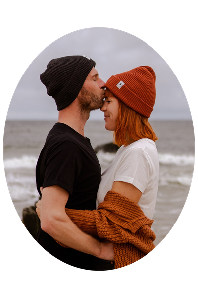 Julia und Patrick vom Reiseblog "globusliebe" stehen innig vor einem Meer