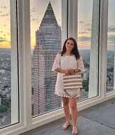 Autorin des Top 50 Reiseblogs "Unterwegs & Daheim" Nicole posiert vor einer großen Fensterfront, im Hintergrund eine Skyline